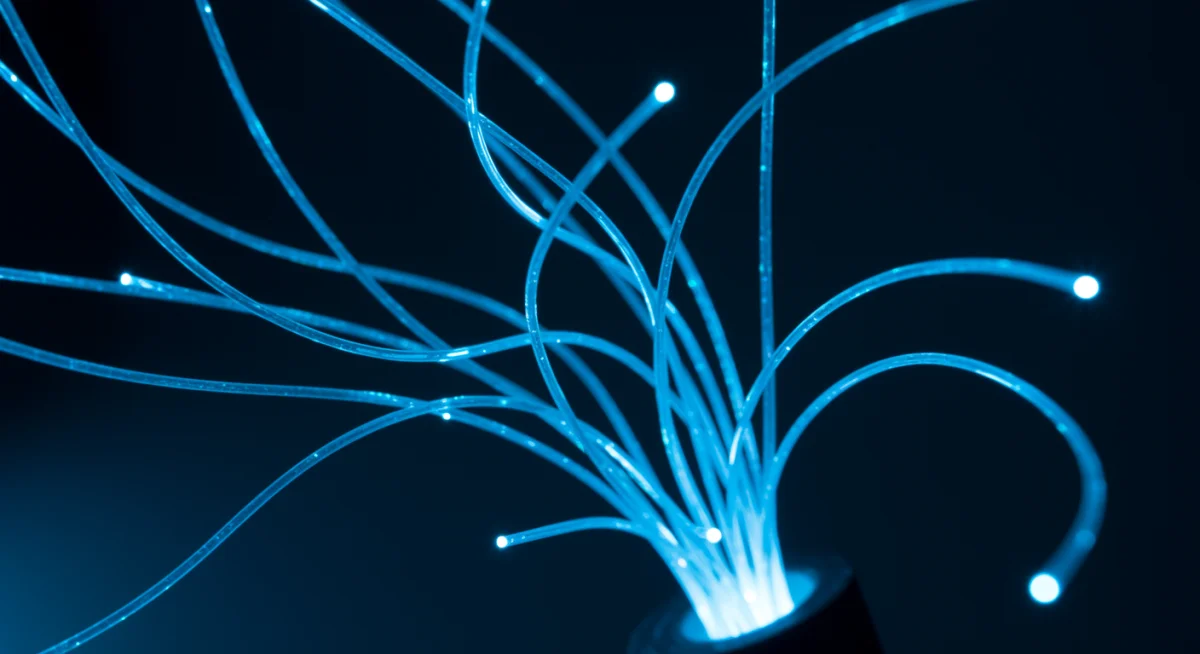 Fiber optic cables glowing blue, symbolizing advanced broadband infrastructure and digital connectivity.